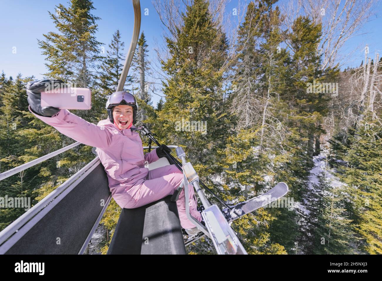 Vacances de ski - femme skieuse dans les remontées mécaniques faisant selfie photo ou vidéo à l'aide du téléphone.Ski hiver concept de vacances.Ski sur les pistes de ski en montagne Banque D'Images