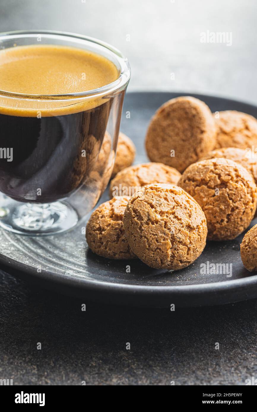 Biscuits amaretti.Petits gâteaux aux amandes italiennes sucrées et tasse de café sur la table de cuisine. Banque D'Images