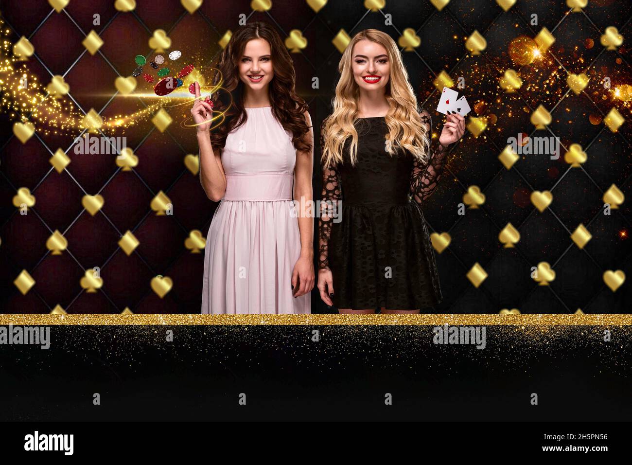 Deux filles présentent deux as et jetons, souriant, posant sur un fond brillant coloré avec des costumes de carte dorés.Jeux de hasard, poker, casino. Banque D'Images