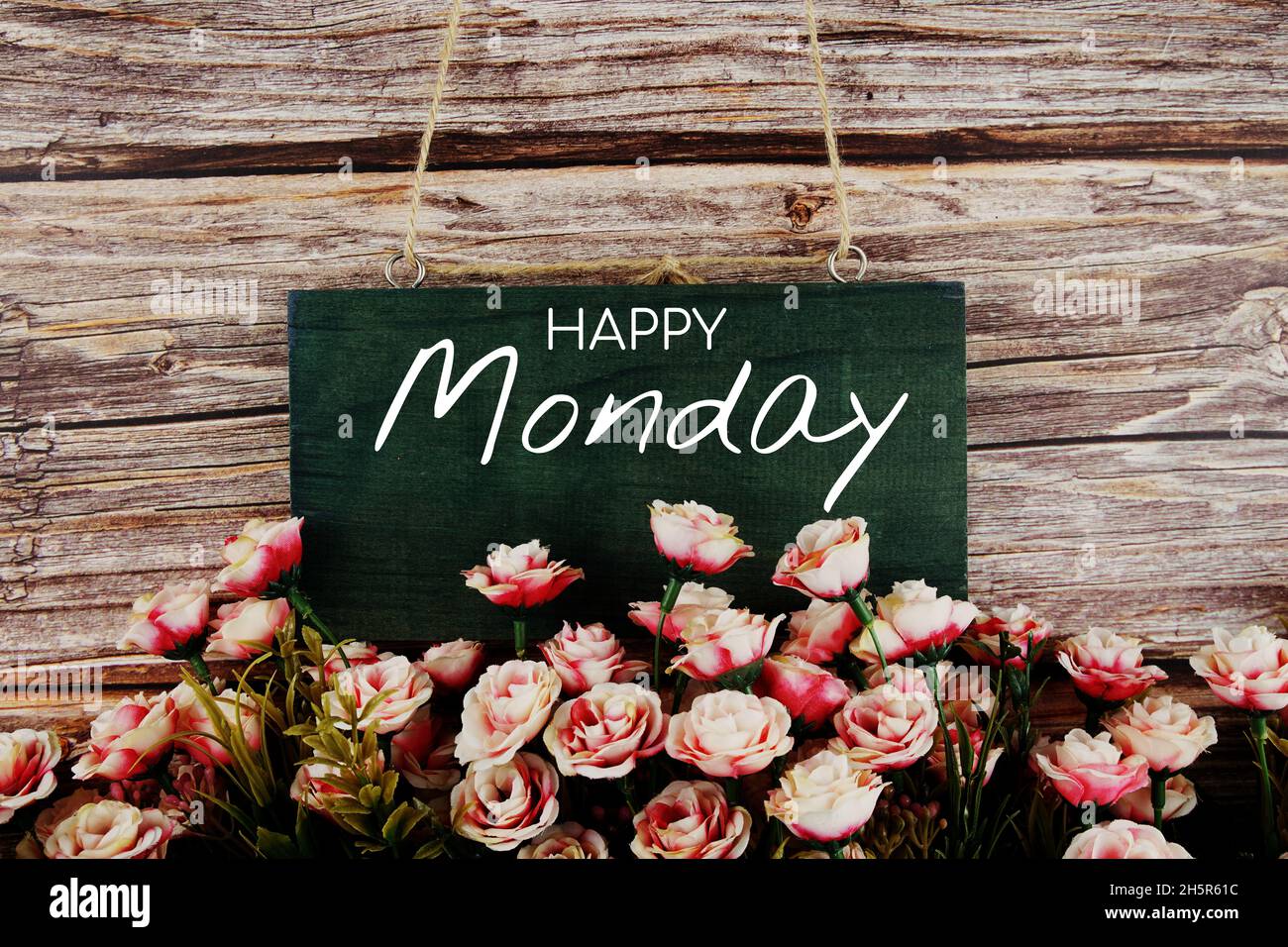 Joyeux lundi texte typographique avec bouquet de fleurs roses sur fond de bois Banque D'Images