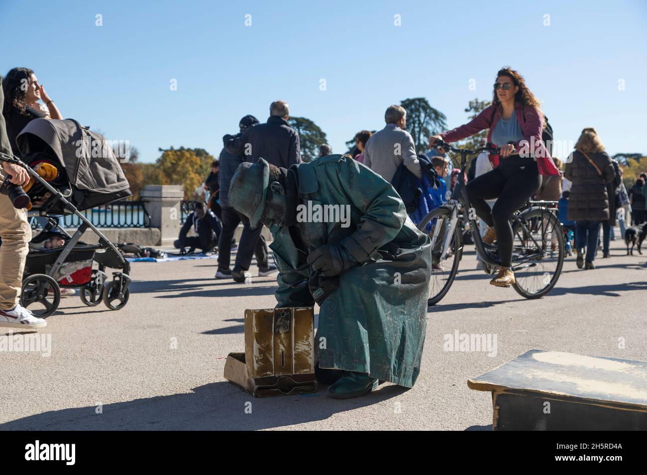 Madrid, Espagne - 09 novembre 2021 : un mime, interprète de rue, déguisé en statue de bronze, recueille des pièces de monnaie et des almes que les gens laissent dans le Retiro Banque D'Images