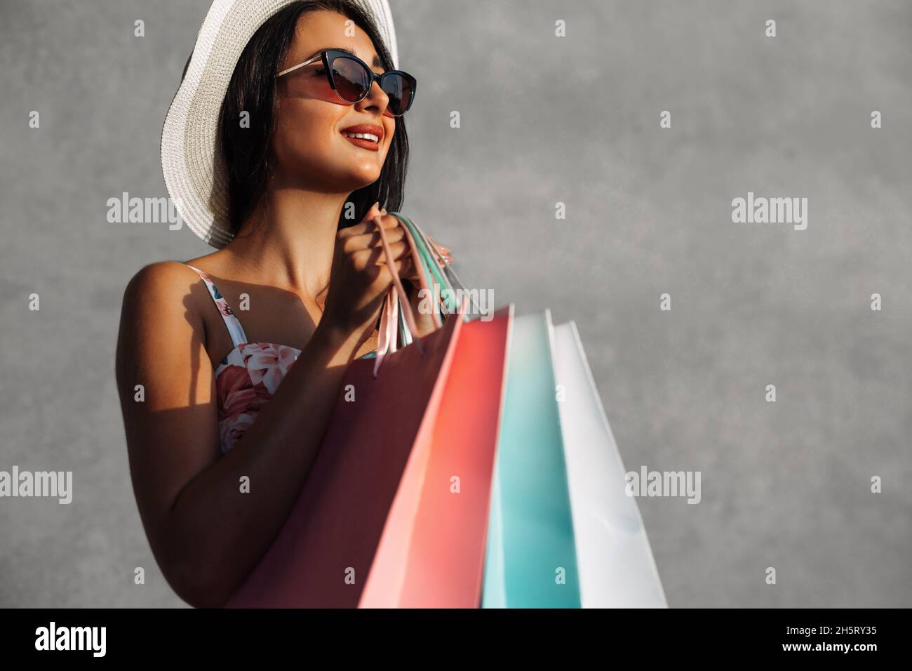 Black Friday, Happy Belle jeune femme en noir lunettes de soleil avec sacs  de shopping, plein air sur fond gris ville mur, vente, mode, concept de  gens Photo Stock - Alamy