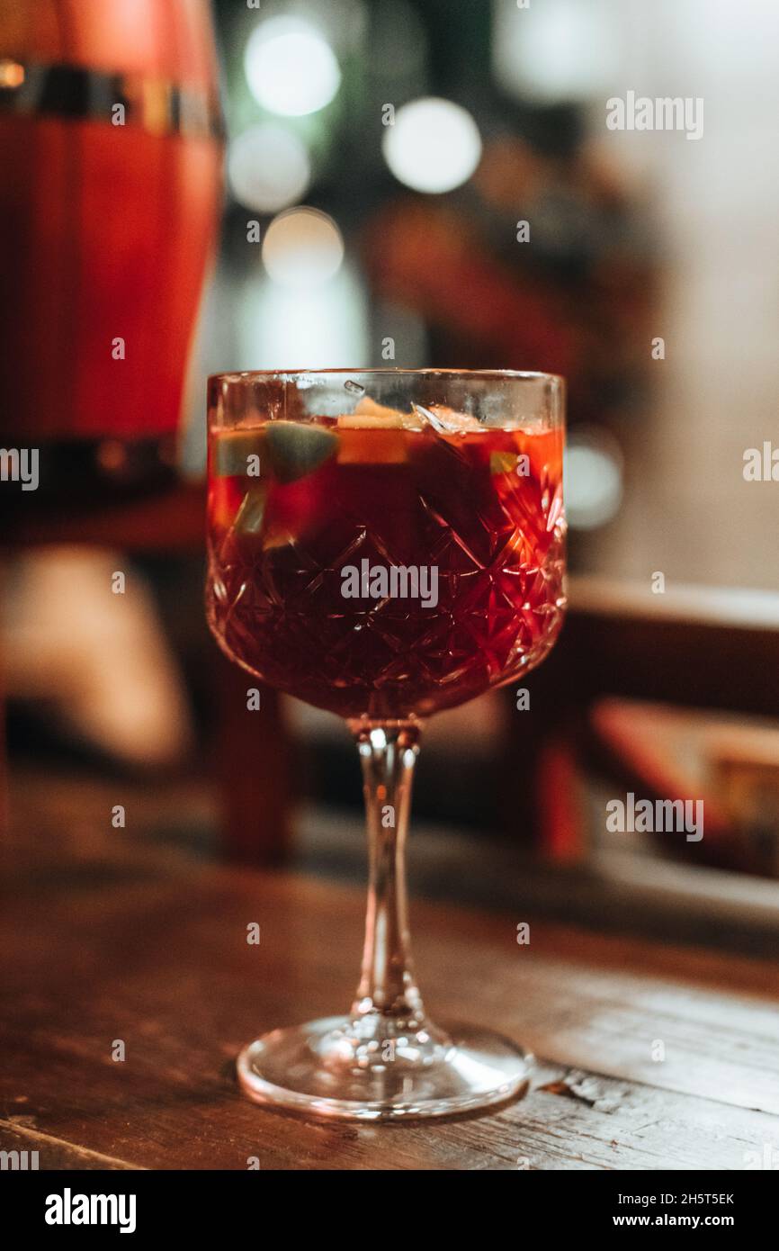 Verre de cristal de vin rouge chaud avec fruits frais et épices sur une table en bois Banque D'Images