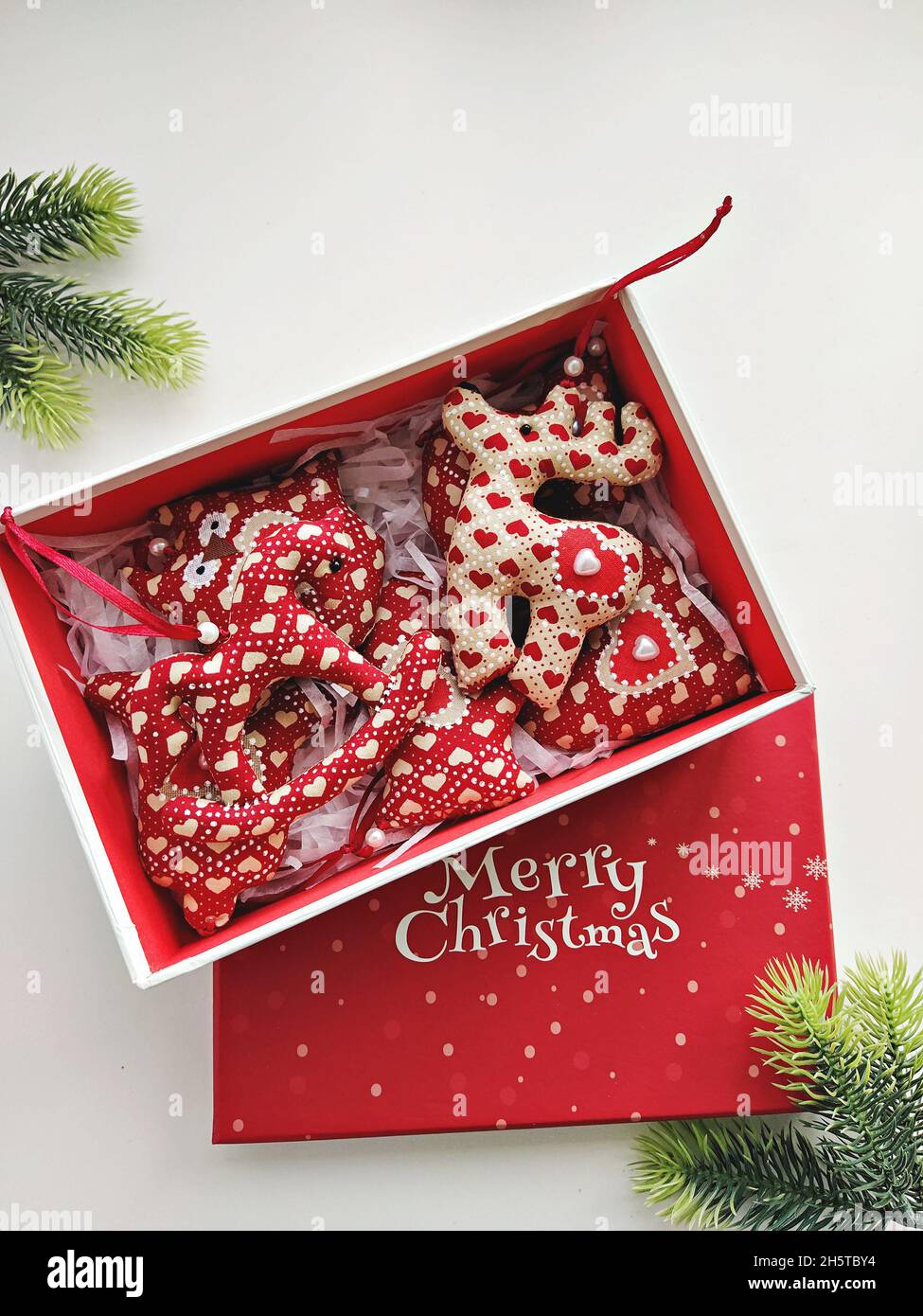 Boîte cadeau rouge avec boules de Noël faites à la main et texte Joyeux Noël Banque D'Images