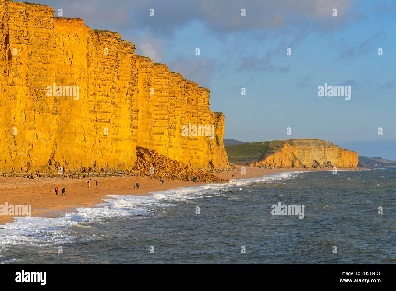 West Bay, Dorset, Royaume-Uni.11 novembre 2021.Météo Royaume-Uni.Marcheurs sur la plage en profitant du soleil de fin d'après-midi à West Bay à Dorset, comme le ciel est clair.La plage est actuellement bloquée par une chute de roche après qu'une partie de la falaise s'est effondrée le mardi 9 novembre.Crédit photo : Graham Hunt/Alamy Live News Banque D'Images