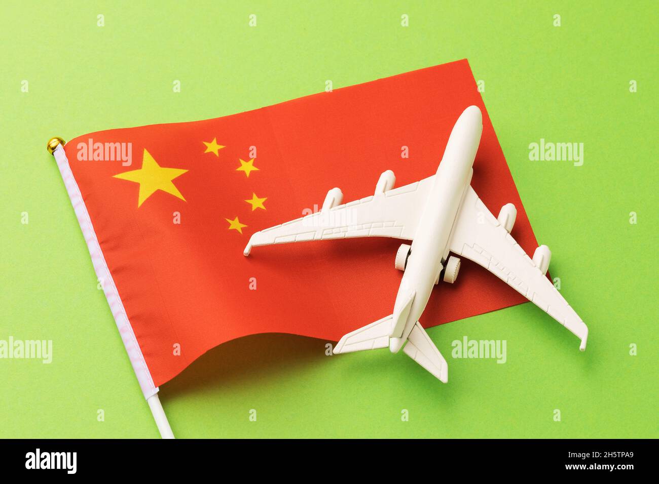 Drapeau de la Chine et un avion jouet sur fond vert, le concept sur le thème du voyage en Chine et les vols intérieurs dans le pays Banque D'Images