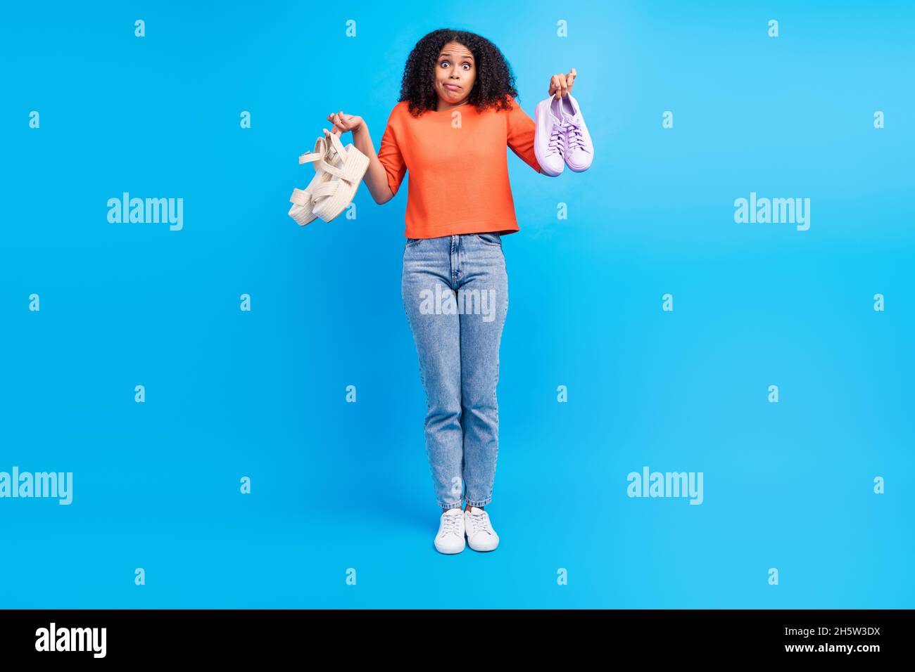 Pleine photo de la jeune femme afro choisir décider acheter chaussures  vente penser isolé sur fond bleu de couleur Photo Stock - Alamy