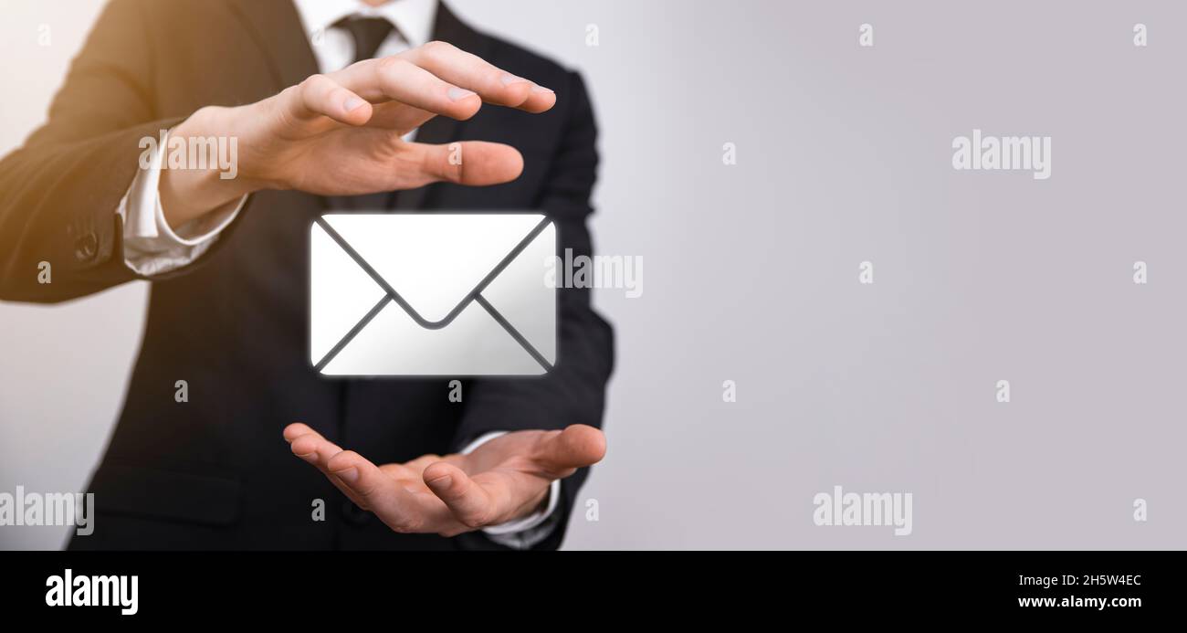 Homme d'affaires main tenant l'icône e-mail, Contactez-nous par e-mail newsletter et protégez vos informations personnelles contre le courrier indésirable.Centre d'appel du service clientèle Banque D'Images