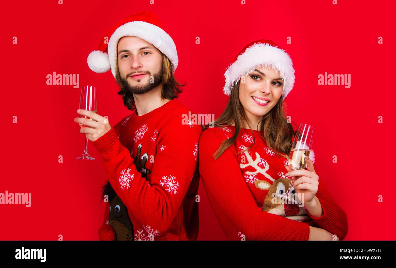 Magnifique couple en chapeaux de père Noël avec champagne.Vacances en famille.Joyeux Noël et Bonne Année.Relations. Banque D'Images