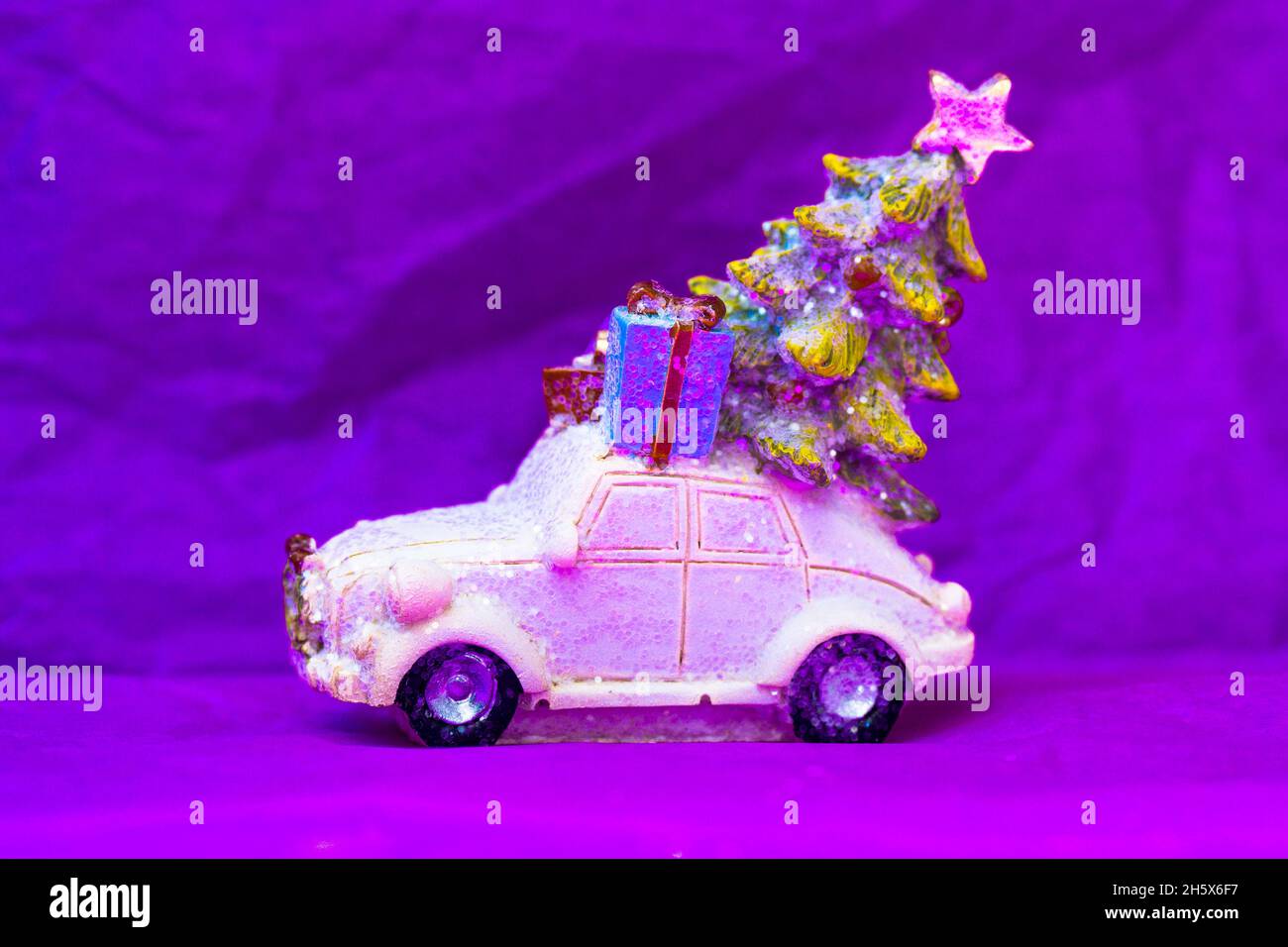 Voiture rétro jouet blanc avec arbre de Noël, boîte cadeau sur un toit sur  fond violet vif.Bonne année 2022.Carte de vœux avec espace de copie.Cadeaux  del Photo Stock - Alamy