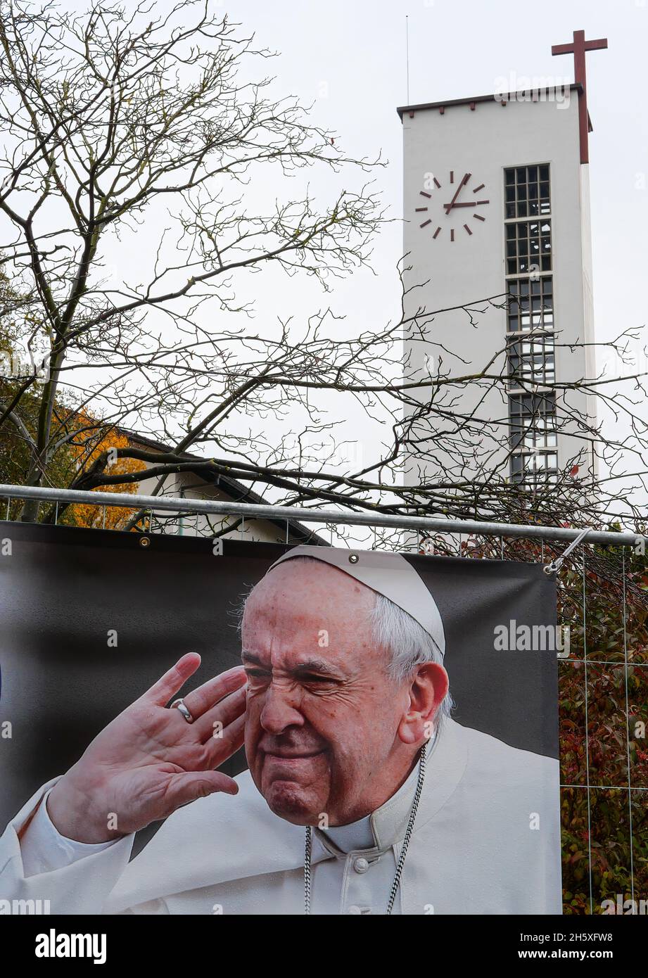 Aarau, Suisse-3 novembre 2021 : une affiche avec l'image du Pape François écoutant attentivement en arrière-plan le clocher de l'église dans Un Banque D'Images Aarau, Suisse-3 novembre 2021 : une affiche avec l'image du Pape François écoutant attentivement en arrière-plan le clocher de l'église dans Un Banque D'Images