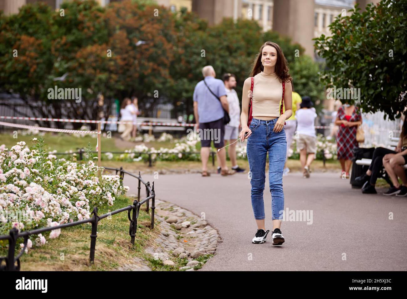 Une femme élancée en Jean marche dans un parc bondé en été Photo Stock -  Alamy
