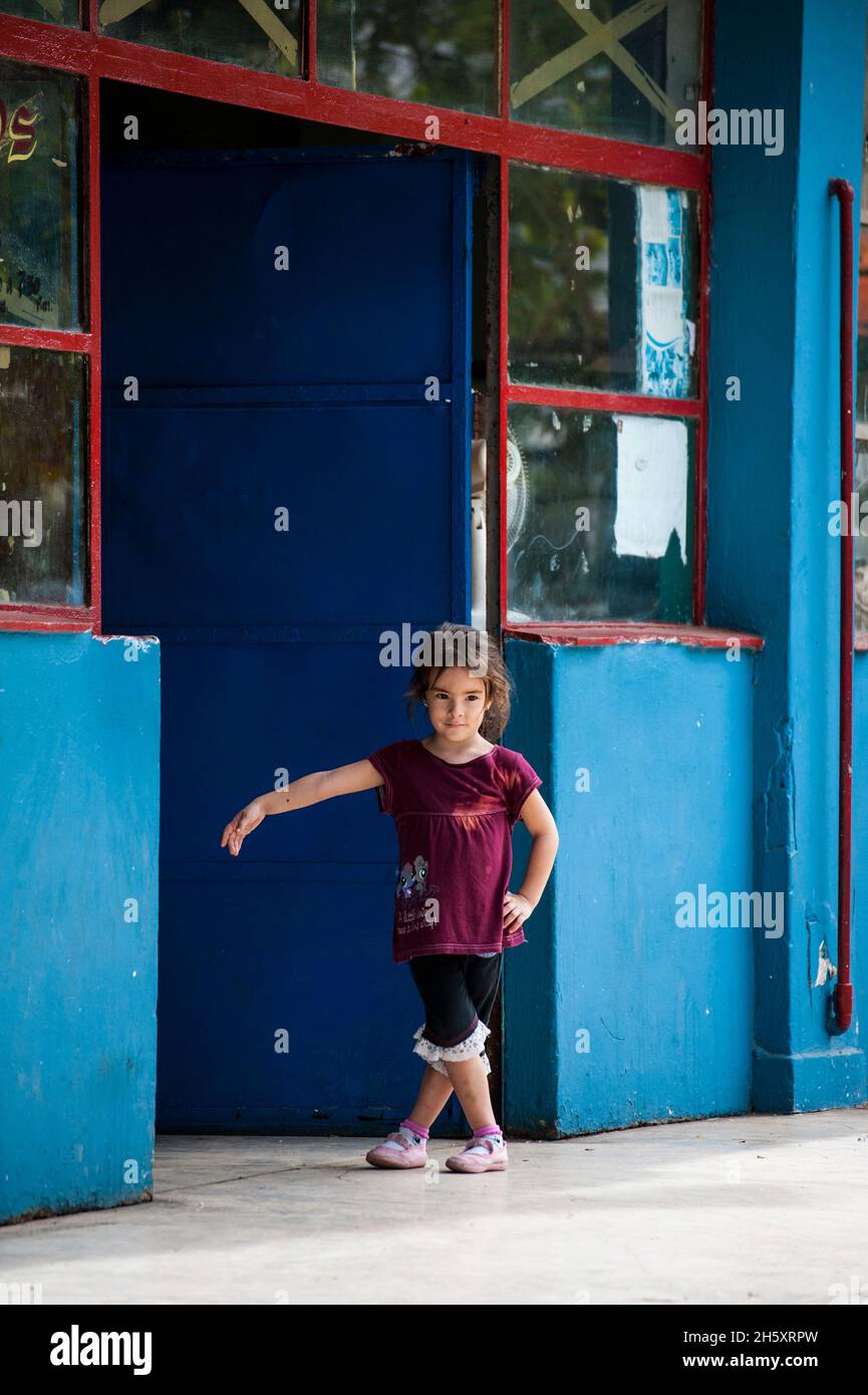 Une jeune fille danse et joue par elle-même dans une porte d'un magasin à la Havane, Cuba Banque D'Images