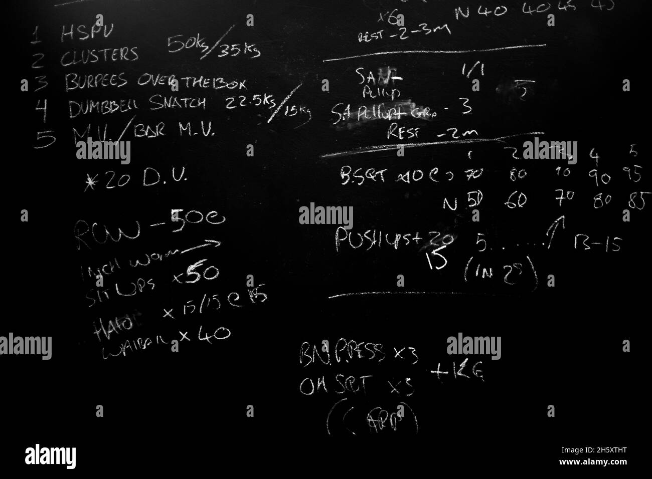Entraînement de la journée sur un tableau noir dans une salle de gym, WOD Banque D'Images