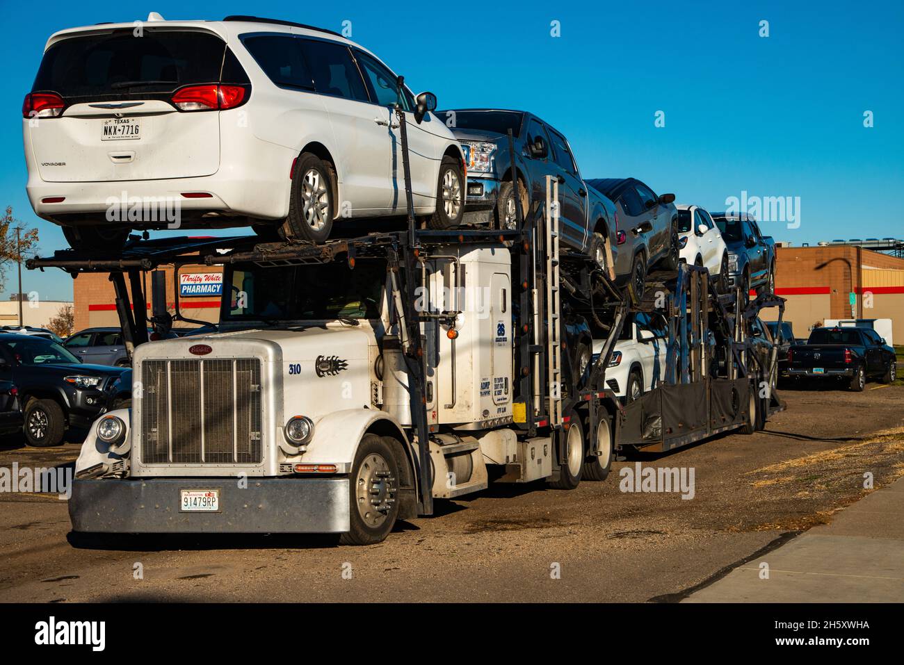 Novembre 10,2021.Bismarck, Dakota du Nord, États-Unis.L'engin de remorque du tracteur avec charge de véhicules attend le déchargement. Banque D'Images