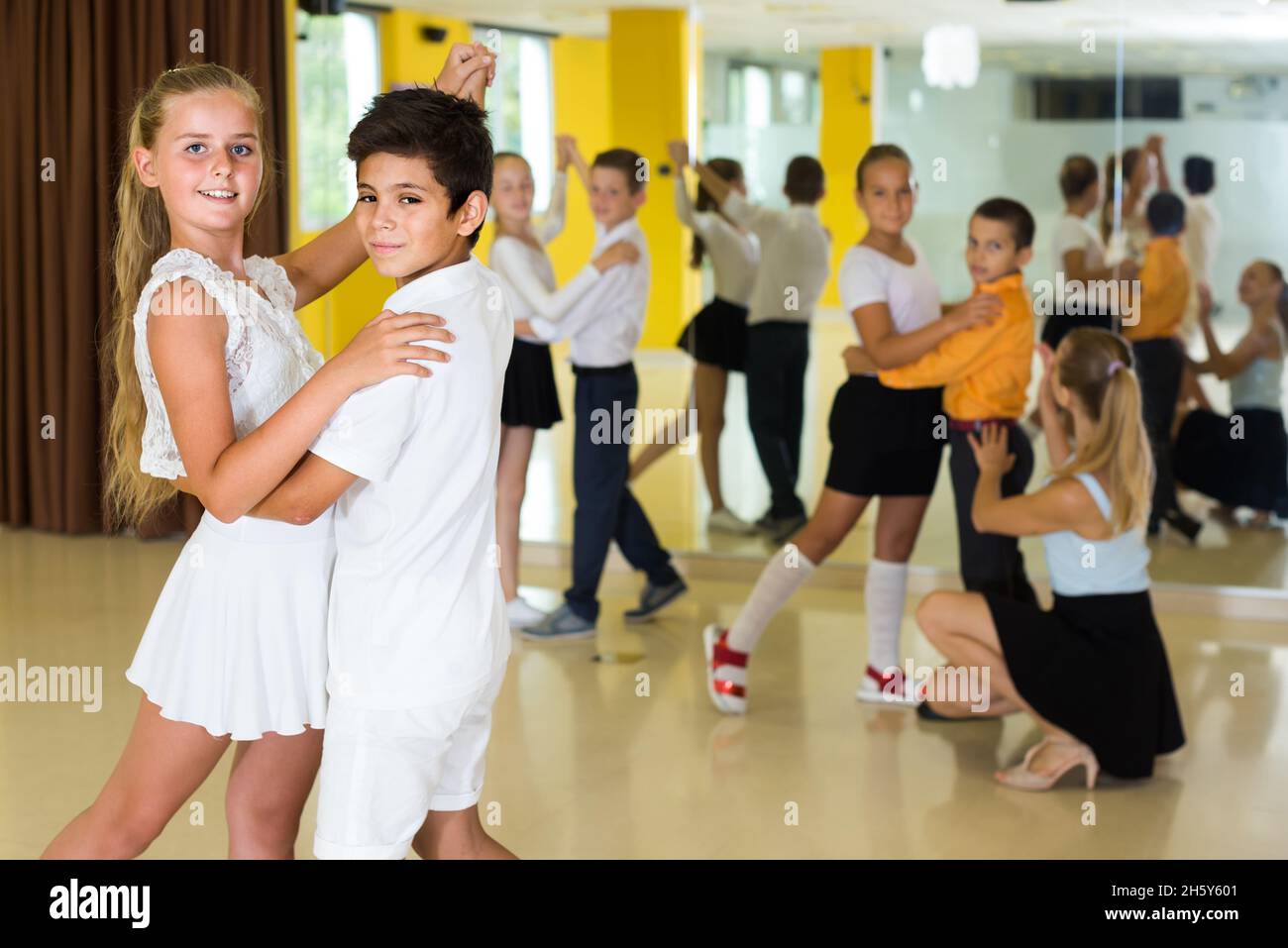 Les enfants dansent en couple en classe Banque D'Images