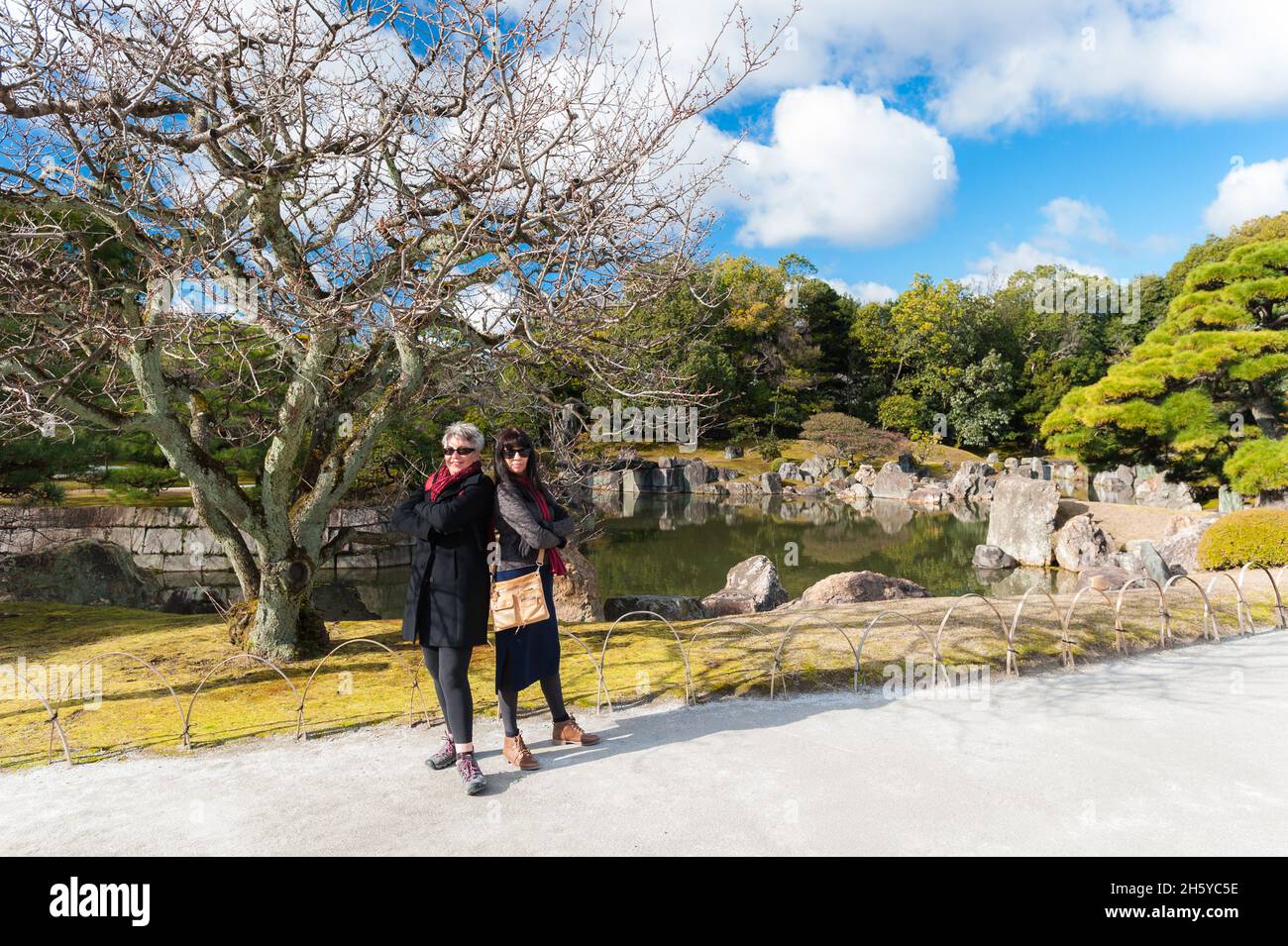 Deux femmes touristes se posant de retour sur le chemin qui mène au-delà de l'un des magnifiques jardins architecturaux du château de Nijo, Kyoto, Japon. Banque D'Images