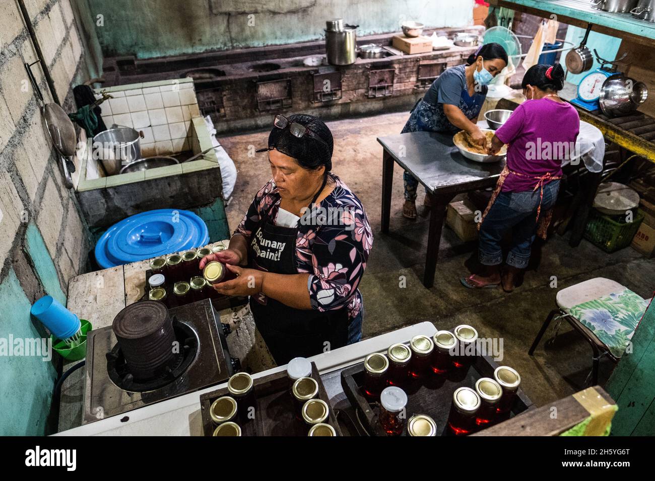 Juillet 2017.Elizabeth Palcay, chef cuisinier, effectue les contrôles de qualité finaux et termine l'emballage de la gelée d'hibiscus.La Kalihan Educational Foundation (KEF) gère une petite confiture, gelée, et d'autres aliments préparés faisant opération dans le cadre de leurs programmes de développement d'entreprise.Imugan, Nueva Vizcaya, Philippines. Banque D'Images