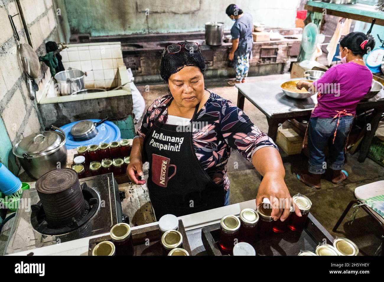 Juillet 2017.Elizabeth Palcay, chef cuisinier, effectue les contrôles de qualité finaux et termine l'emballage de la gelée d'hibiscus.La Kalihan Educational Foundation (KEF) gère une petite confiture, gelée, et d'autres aliments préparés faisant opération dans le cadre de leurs programmes de développement d'entreprise.Imugan, Nueva Vizcaya, Philippines. Banque D'Images