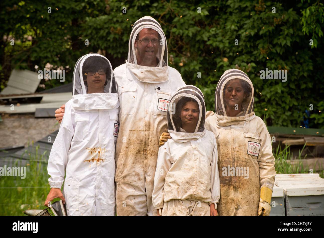 Une famille de apiculture portant des vêtements de protection près de leurs ruches ca.8 juin 2017 Banque D'Images