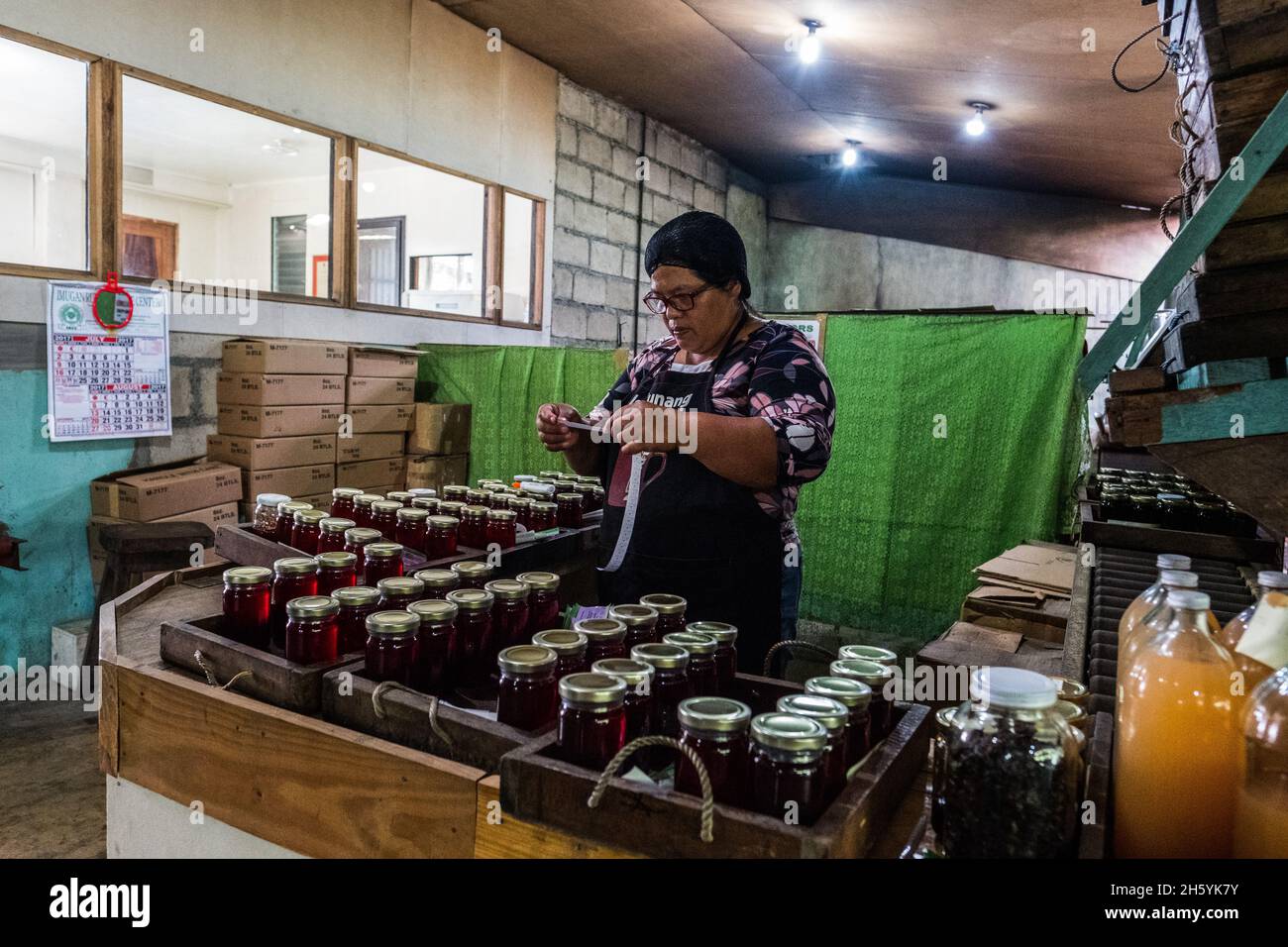 Juillet 2017.Elizabeth Palcay, chef cuisinier, effectue les contrôles de qualité finaux et termine l'emballage de la gelée d'hibiscus.La Kalihan Educational Foundation (KEF) gère une petite confiture, gelée, et d'autres aliments préparés faisant opération dans le cadre de leurs programmes de développement d'entreprise.Imugan, Nueva Vizcaya, Philippines. Banque D'Images