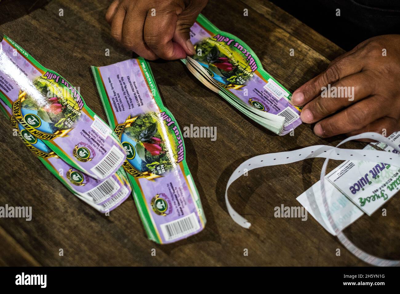Juillet 2017.Préparation des étiquettes pour un lot de gelée d'hibiscus.La Kalihan Educational Foundation (KEF) gère une petite confiture, gelée, et d'autres aliments préparés faisant opération dans le cadre de leurs programmes de développement d'entreprise.Imugan, Nueva Vizcaya, Philippines. Banque D'Images