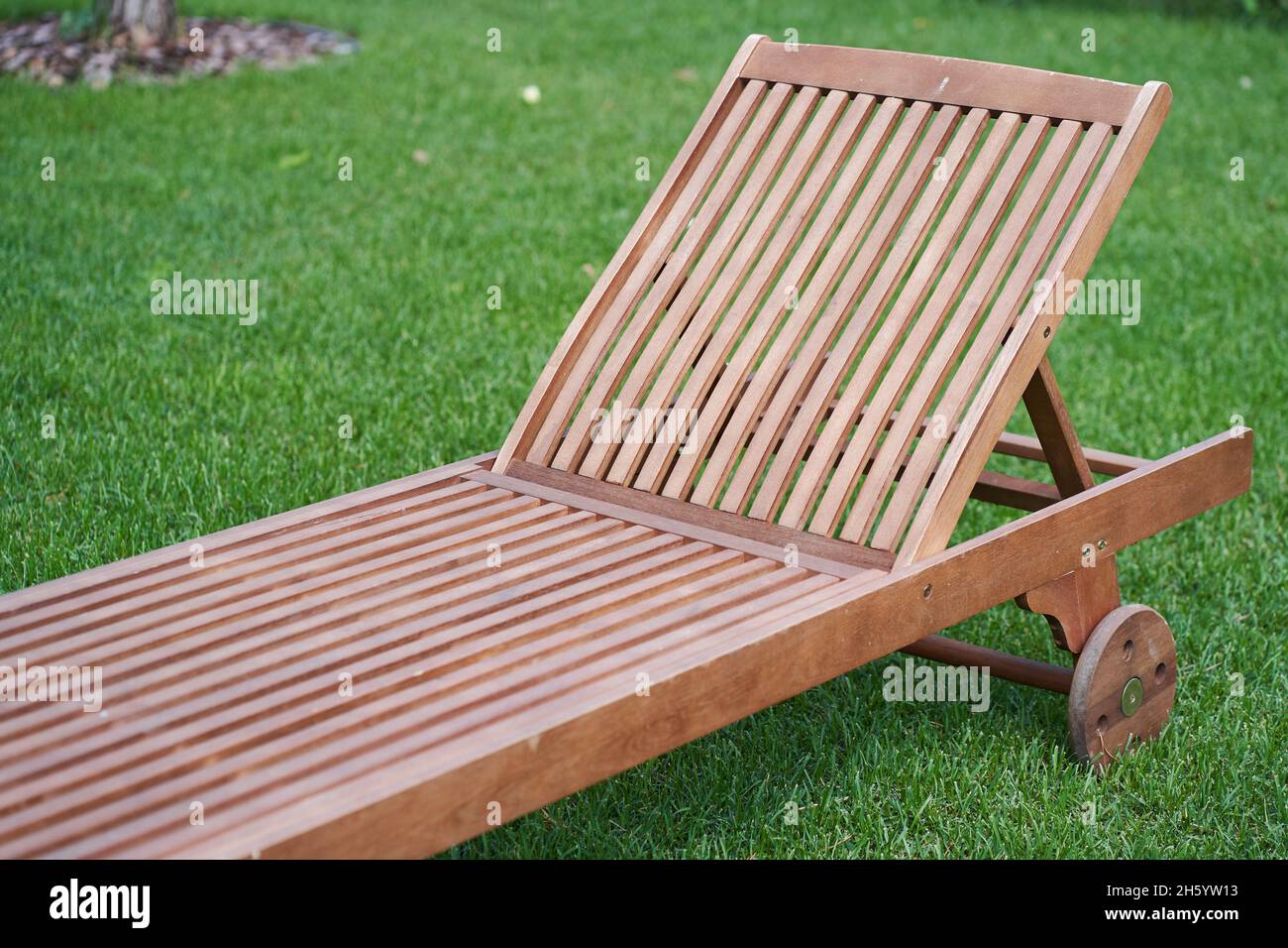 Gros plan d'une chaise longue en bois dans un jardin frais sur l'herbe  verte.le concept de détente, bronzage dans l'arrière-cour. Photo de haute  qualité Photo Stock - Alamy