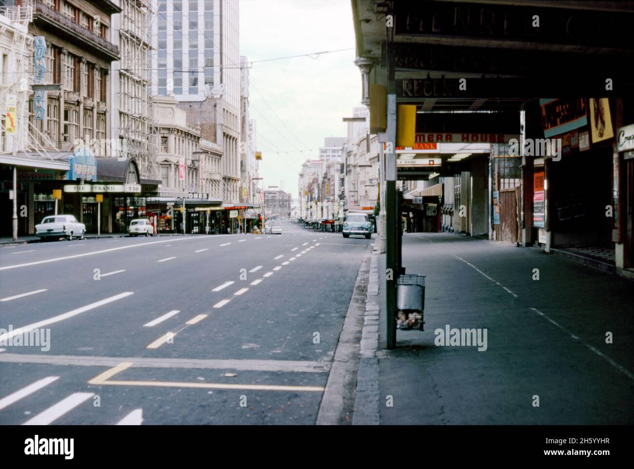 Vue vers le nord sur Queen Street, Auckland, Nouvelle-Zélande en 1973.Le manque de gens et de circulation dans la rue principale de la ville peut signifier que c'est un dimanche.Queen Street est la principale artère commerciale et commerciale du quartier central des affaires (CBD).Le Strand Arcade est à gauche.A côté, le cinéma Cinerama montre le film ‘Deliverance’.Cette image provient d'un ancien transparent couleur Kodak amateur, une photographie vintage des années 1970. Banque D'Images