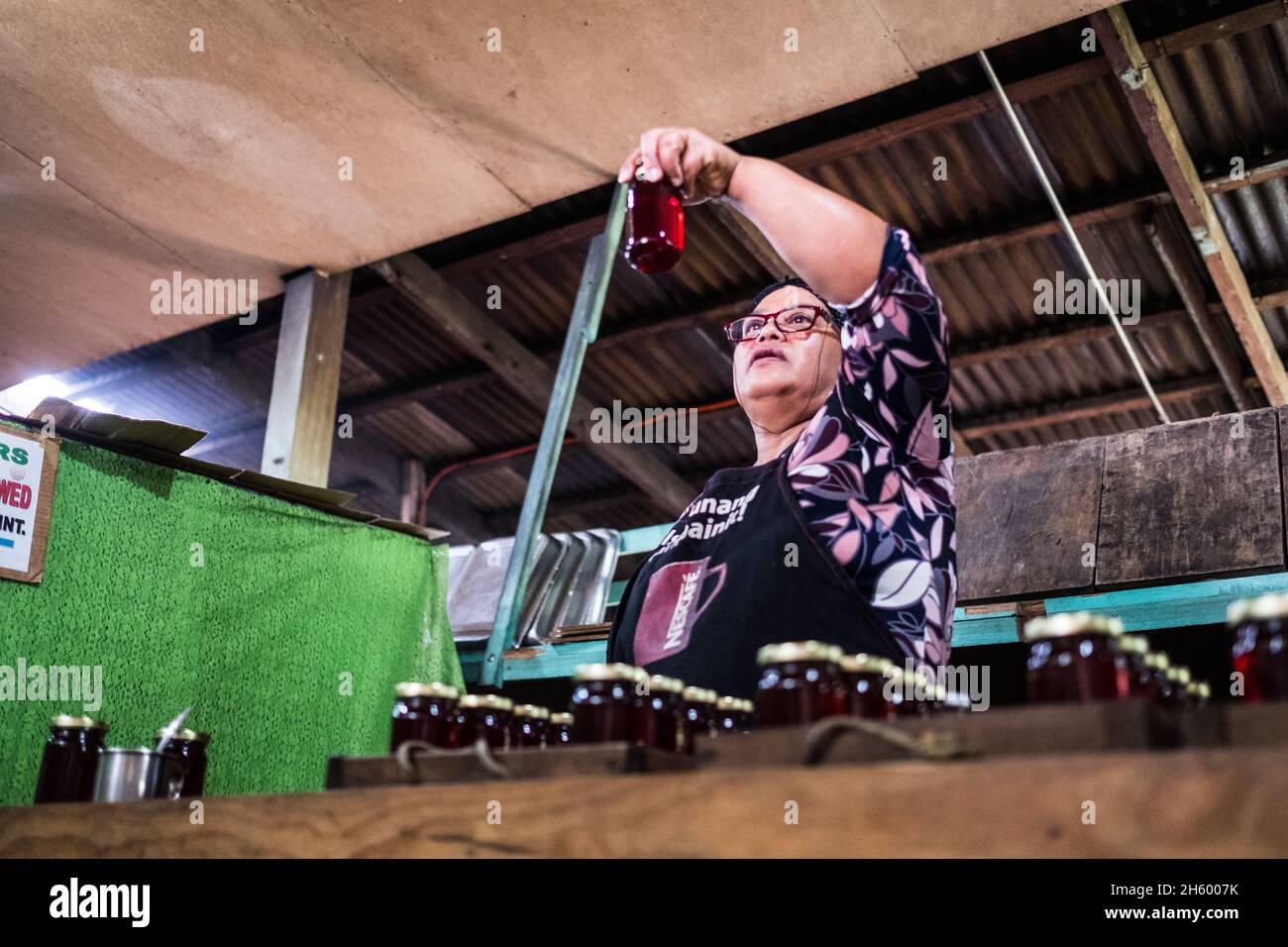 Juillet 2017.Elizabeth Palcay, chef cuisinier, effectue les contrôles de qualité finaux et termine l'emballage de la gelée d'hibiscus.La Kalihan Educational Foundation (KEF) gère une petite confiture, gelée, et d'autres aliments préparés faisant opération dans le cadre de leurs programmes de développement d'entreprise.Imugan, Nueva Vizcaya, Philippines. Banque D'Images