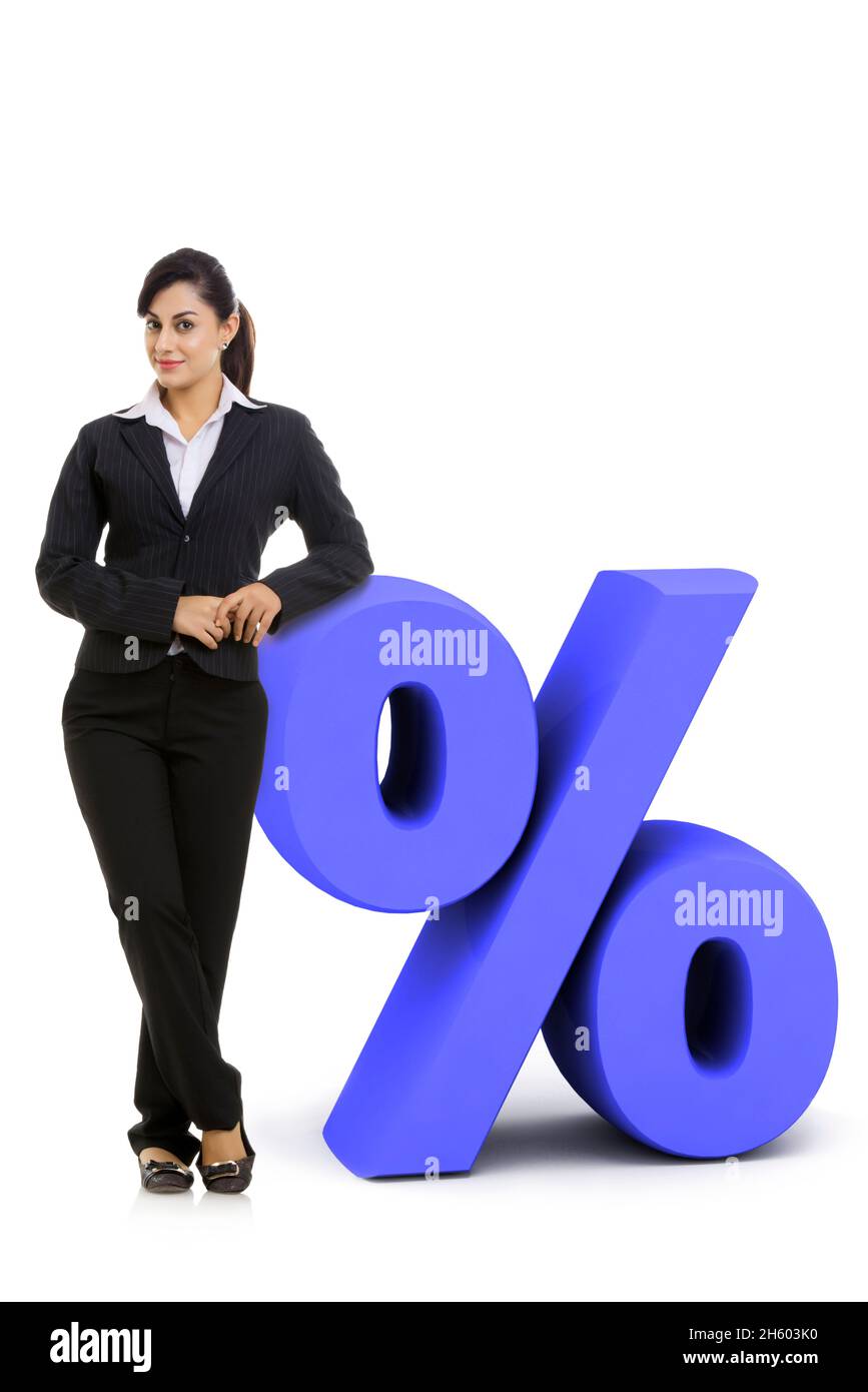Une employée d'entreprise en costume d'affaires formel debout à côté d'un signe %. Banque D'Images