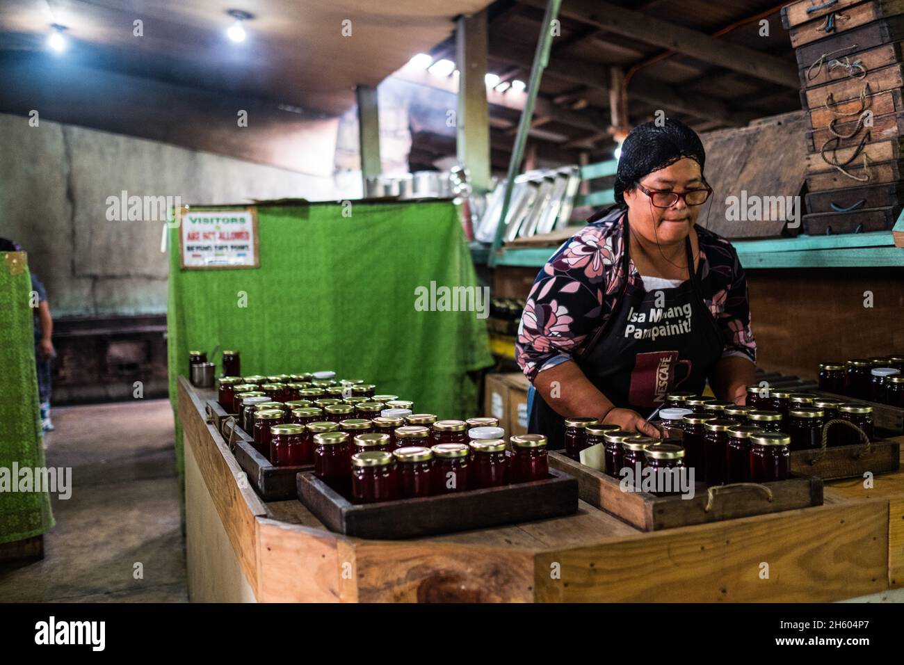Juillet 2017.Elizabeth Palcay, chef cuisinier, effectue les contrôles de qualité finaux et termine l'emballage de la gelée d'hibiscus.La Kalihan Educational Foundation (KEF) gère une petite confiture, gelée, et d'autres aliments préparés faisant opération dans le cadre de leurs programmes de développement d'entreprise.Imugan, Nueva Vizcaya, Philippines Banque D'Images