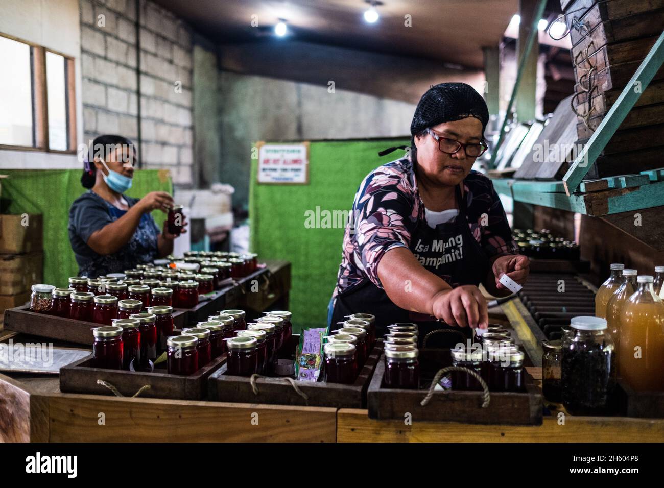 Juillet 2017.Elizabeth Palcay, chef cuisinier, effectue les contrôles de qualité finaux et termine l'emballage de la gelée d'hibiscus.La Kalihan Educational Foundation (KEF) gère une petite confiture, gelée, et d'autres aliments préparés faisant opération dans le cadre de leurs programmes de développement d'entreprise.Imugan, Nueva Vizcaya, Philippines. Banque D'Images