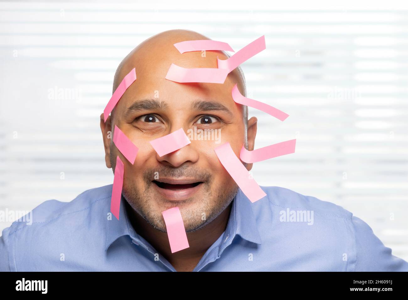 Portrait d'un homme chauve avec des notes collantes sur le visage, souriant. Banque D'Images