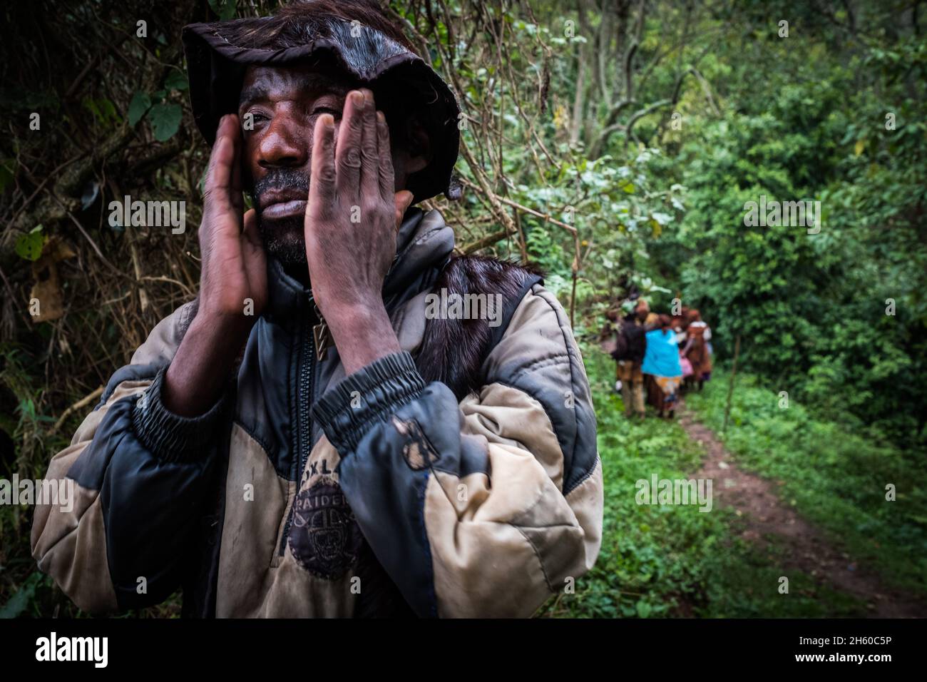 Septembre 2017.Le guide Batwa, Machate Emanuel, dirige la visite du sentier forestier communautaire de Buniga dans sa langue locale, les Pygmées de Batwa ont été expulsées de leurs terres d'origine dans la forêt au début des années 1990, lorsque les parcs nationaux ont été établis,les laisser sans terre et pauvres dans une société qui les considérait comme une classe inférieure.Aujourd'hui, certains d'entre eux essaient de faire la rencontre des extrémités en organisant des promenades sur les sentiers; des visites culturelles qui incluent des exemples de l'endroit et de la façon dont ils utilisent pour vivre dans la forêt, ainsi que du chant, de la danse et de l'artisanat pour la vente.Nkuringo, Ouganda. Banque D'Images