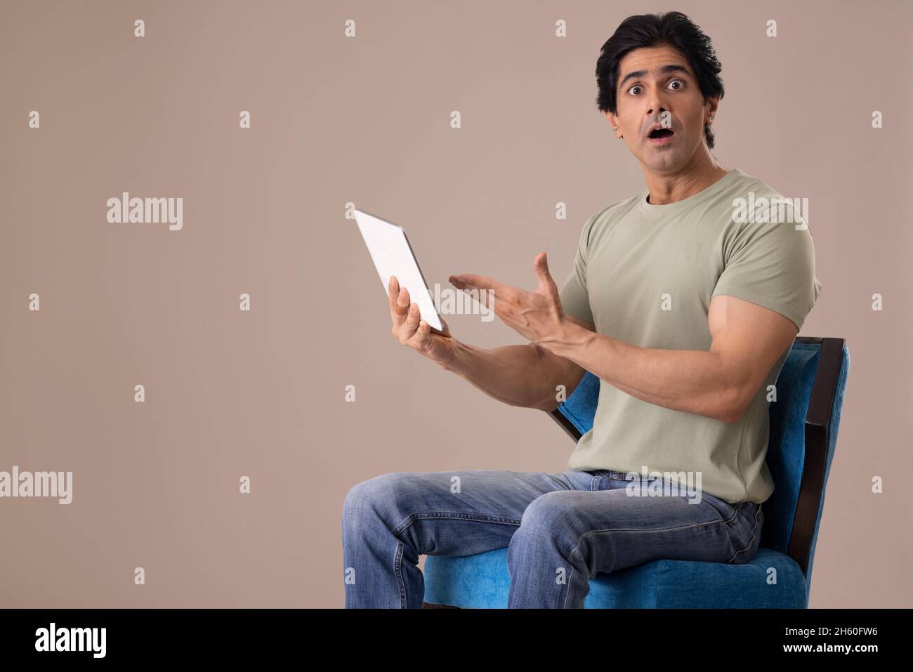 Un Indien heureux posant devant l'appareil photo avec une tablette Banque D'Images