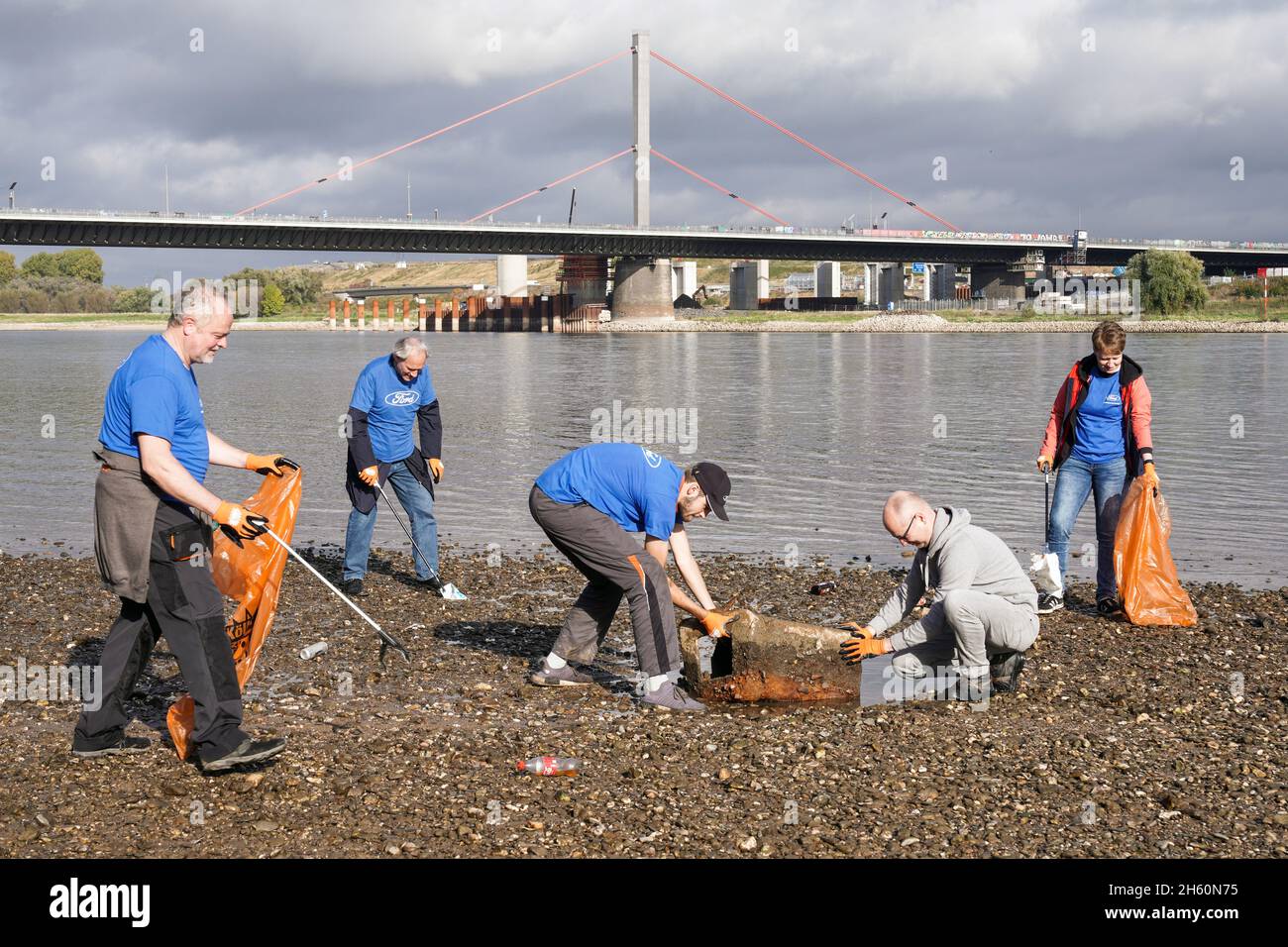 Équipés de pinces et de sacs à ordures recyclables, des volontaires de l'organisation environnementale KRAKE e.V. collectent des ordures sur la rive gauche du Rhin, devant le pont Leverkusen près de Cologne, le 26 octobre 2021 --- ausgestattet mit Greifzangen und recycelbaren Müllsäcken sammeln Freiwillige der Umweltorganization KRAKE e.V. das linkssheinische Ufer vor der Leverkusener Brücke BEI Köln Unrat und Müll.Köln, 26.10.2021 Banque D'Images