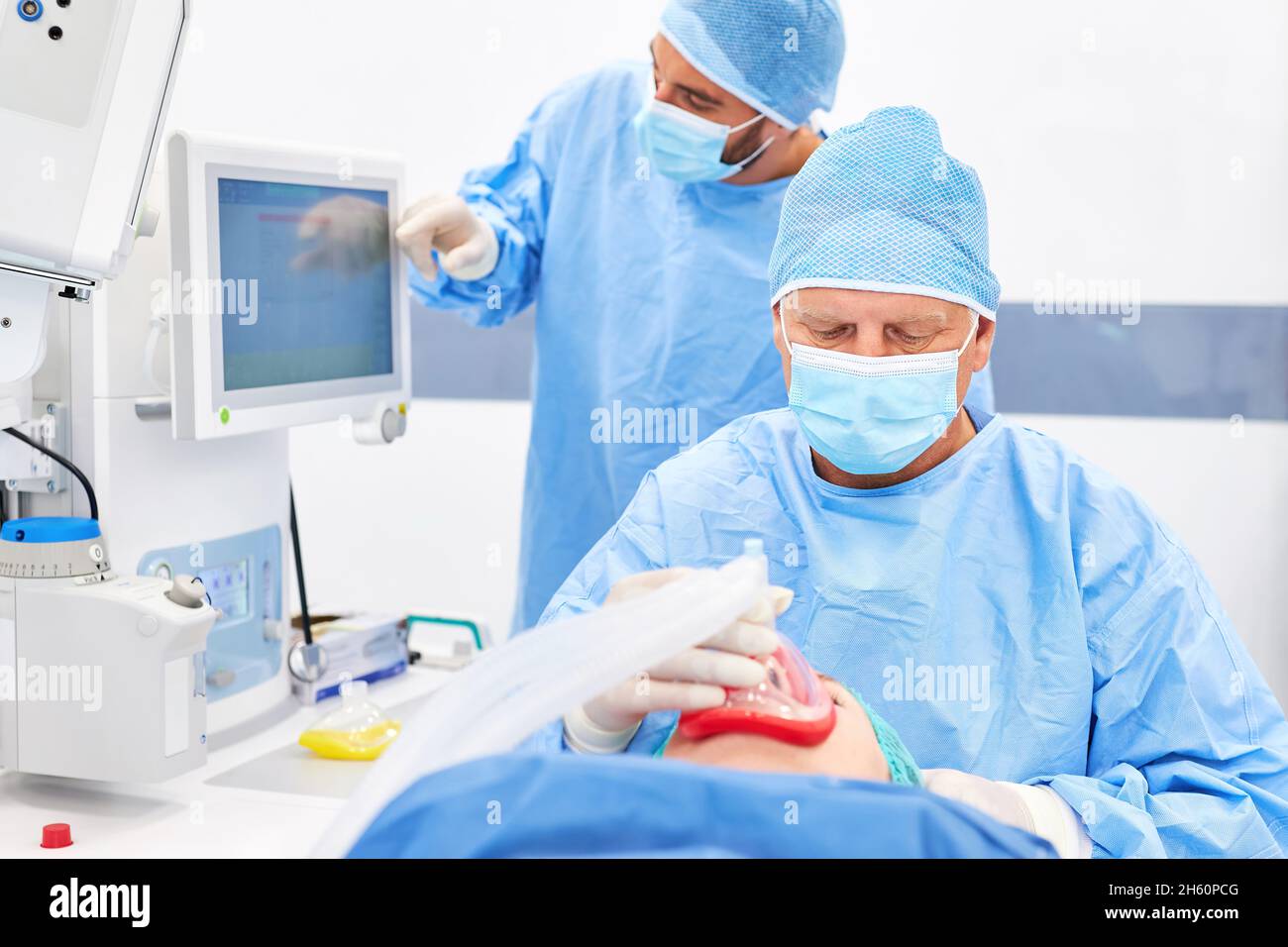 L'anesthésiste et le médecin assistant surveillent attentivement l'anesthésie du patient avant l'opération Banque D'Images