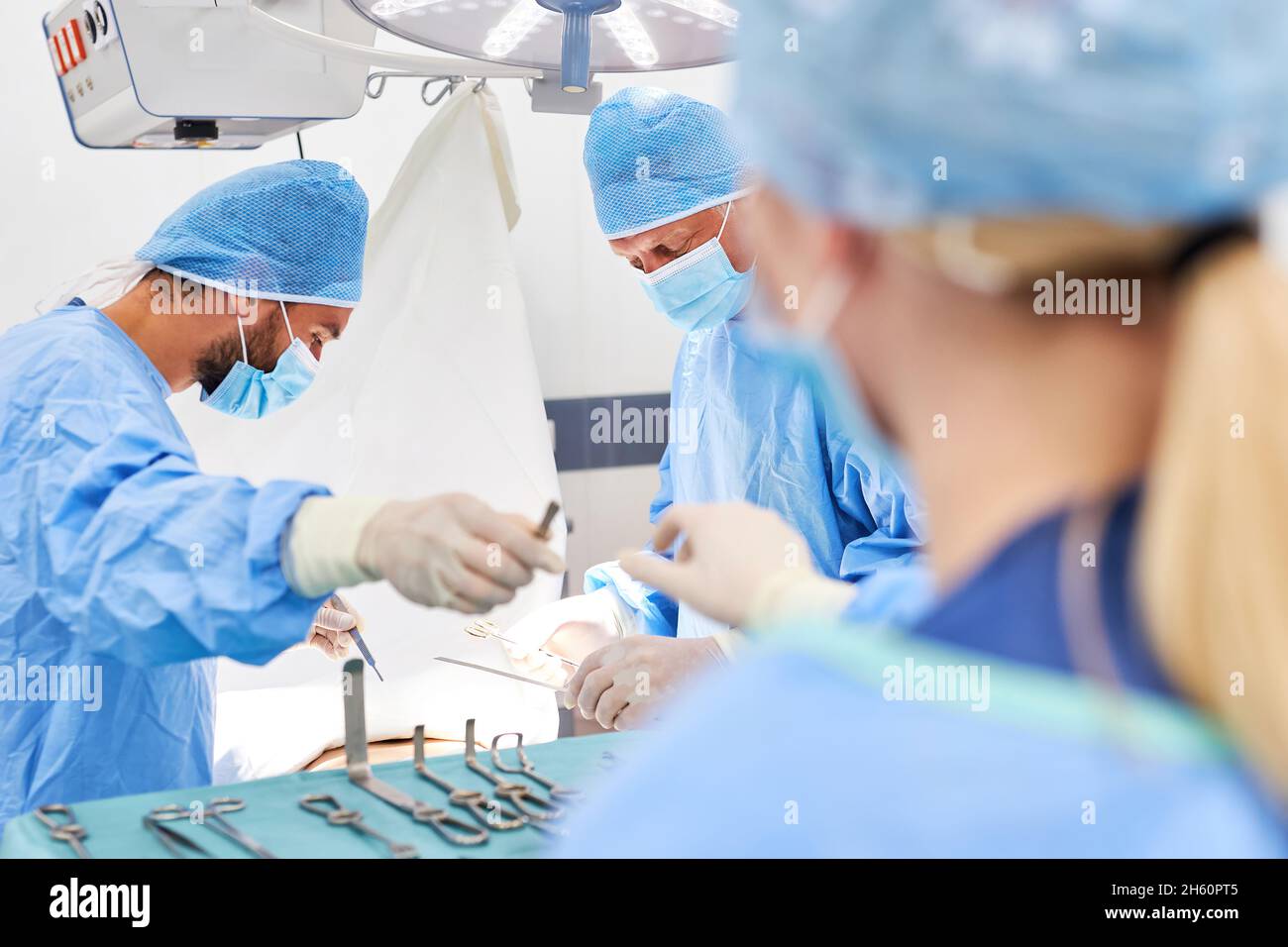 L'équipe de chirurgie travaille ensemble pendant l'opération sur un patient dans la salle d'opération Banque D'Images