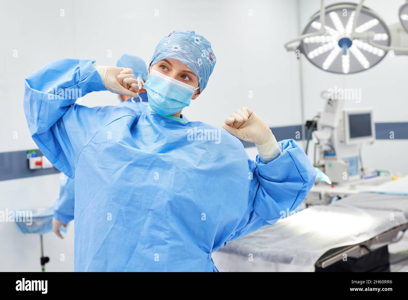 Une infirmière en salle d'opération fatiguée s'étire dans la salle d'opération après une opération fatigante Banque D'Images