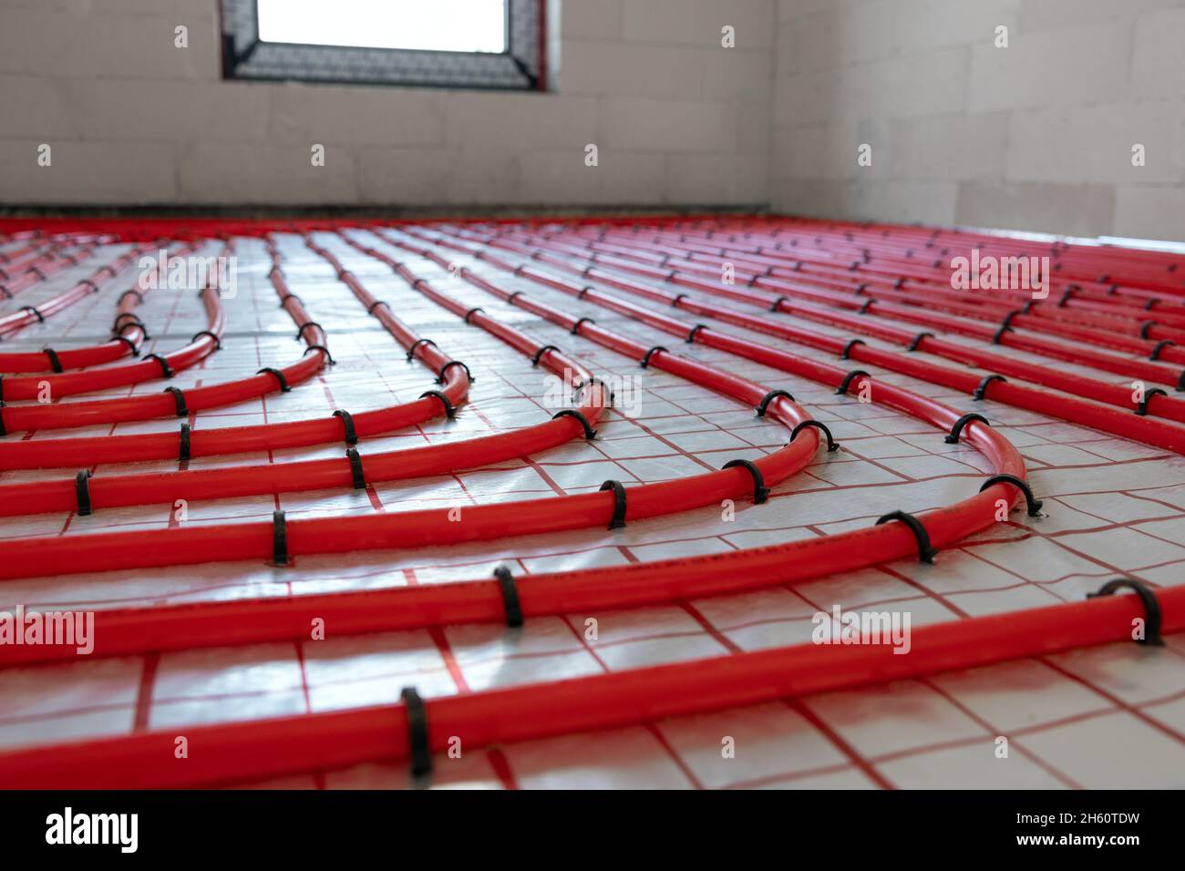 installation du système de chauffage au sol. tuyaux en plastique rouge Banque D'Images