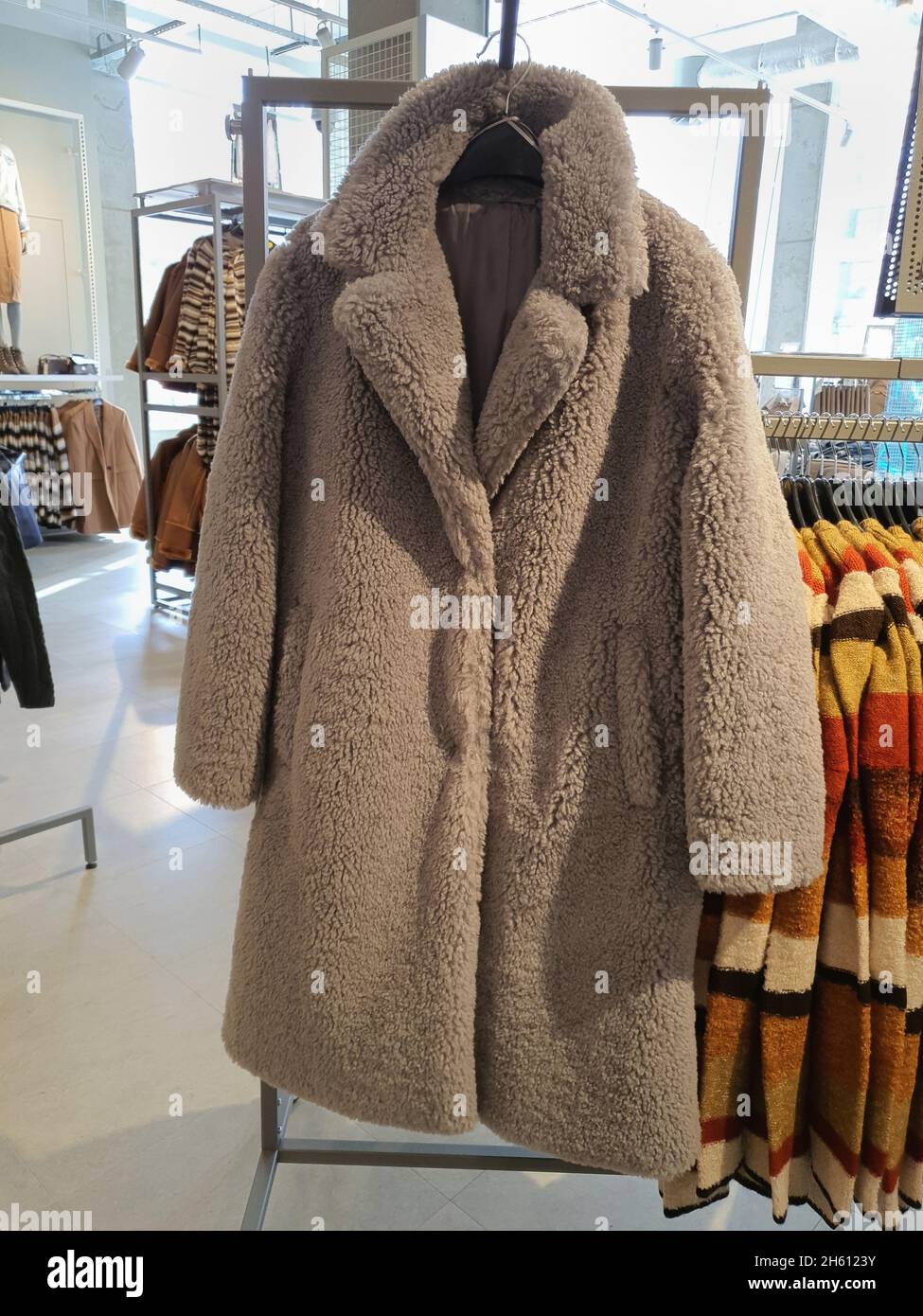 Le manteau de grande taille tendance Teddy Bear est accroché sur le  porte-vêtements dans le magasin de vêtements.Style automnal tendance.Femme  vêtements mode concept.Couleurs neutres, mise au point sélective Photo  Stock - Alamy