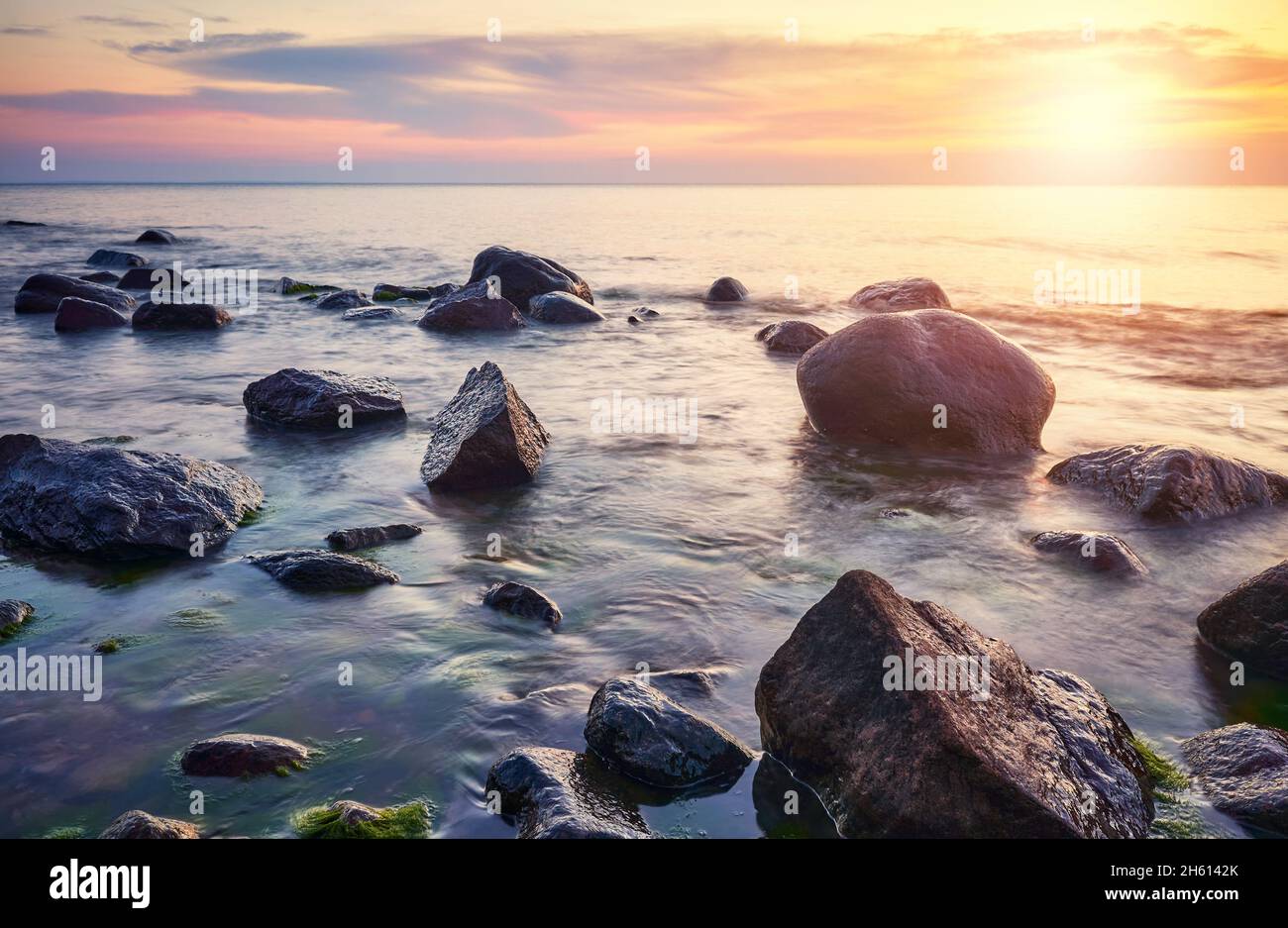 Rocky plage de la mer Baltique à un beau coucher de soleil. Banque D'Images