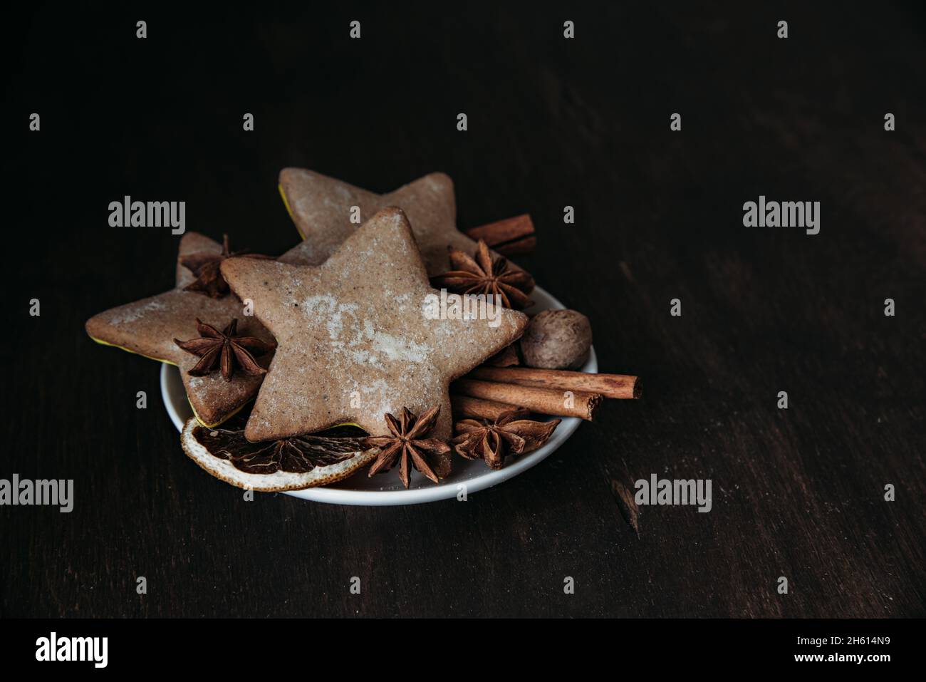 Pain d'épice de Noël en forme d'étoiles, d'épices et de miel sur une table en bois. Banque D'Images