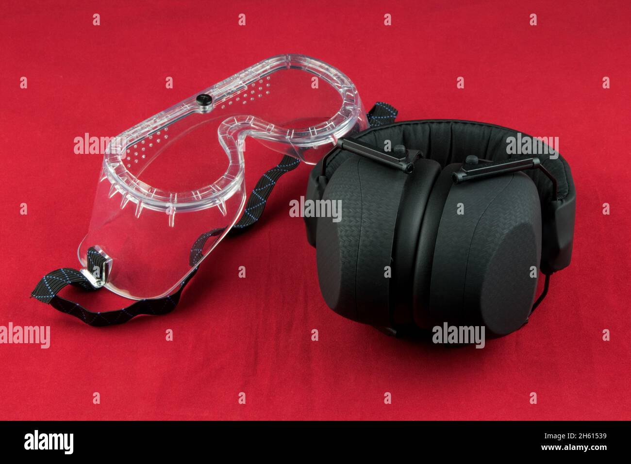 Protections auditives et lunettes de sécurité isolées sur fond rouge Banque D'Images