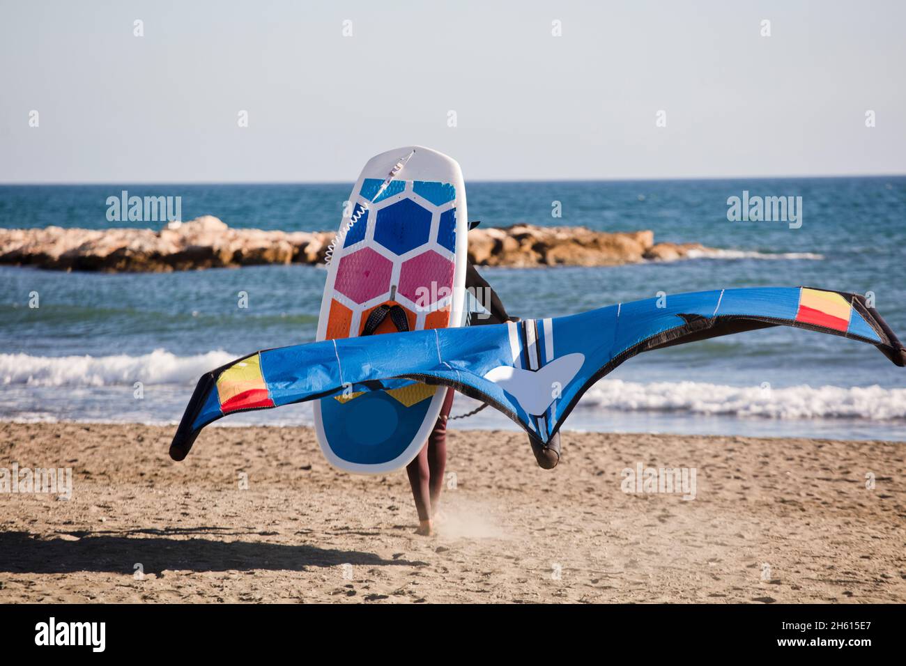 l'homme marche avec l'équipement pour pratiquer le papier d'aluminium sur la plage Banque D'Images