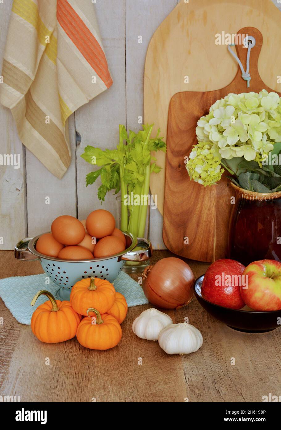 Fruits et légumes de l'automne avec planches à découper et torchon à thé dans un cadre rustique en format vertical. Banque D'Images
