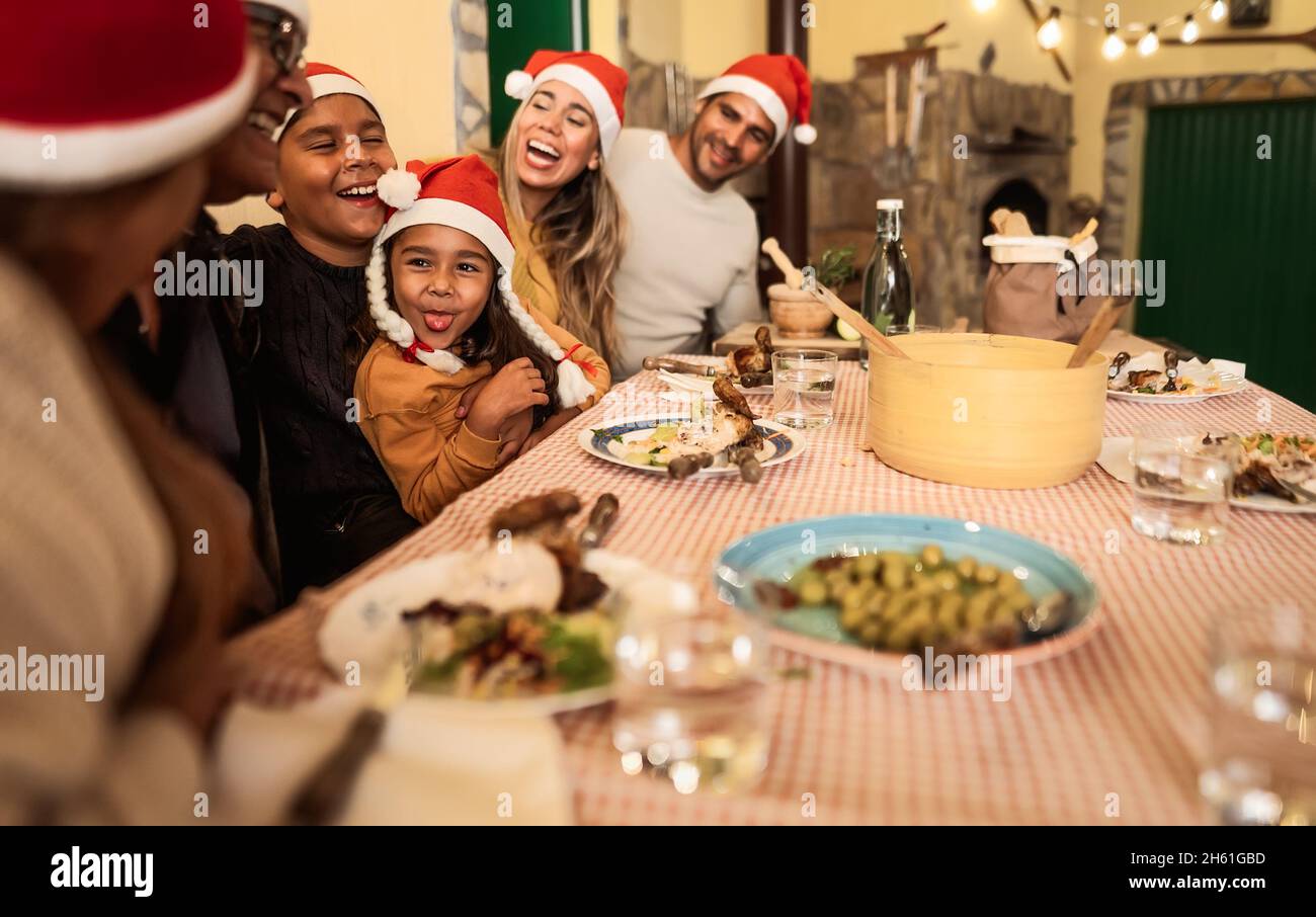 Bonne famille latine s'amuser à célébrer les vacances de Noël tout en dînant ensemble à la maison Banque D'Images