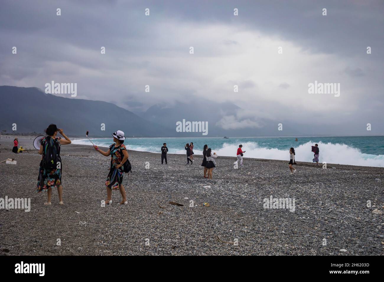 les touristes prennent des photos sur la plage rocheuse de loisirs scéniques Banque D'Images
