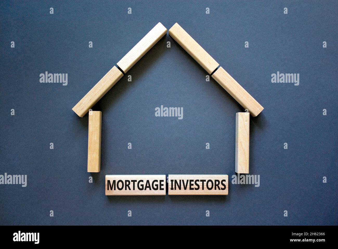 Symbole des investisseurs hypothécaires.Mots-clés 'Mortgage Investors' sur des blocs de bois près de la maison en bois miniature.Magnifique fond gris.Affaires, morg Banque D'Images