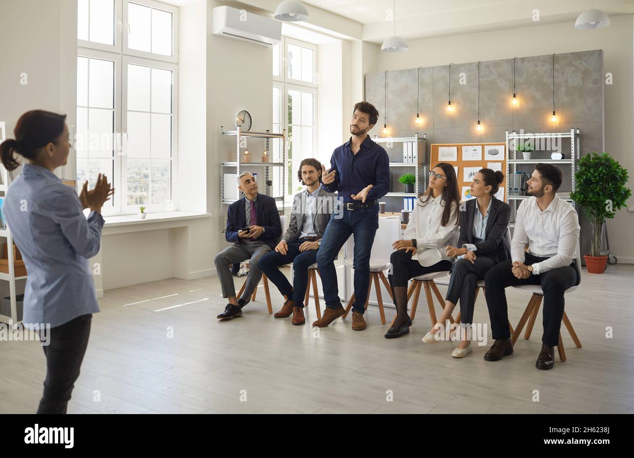 Groupe de personnes d'affaires ayant des entretiens avec un coach professionnel pendant l'atelier Banque D'Images